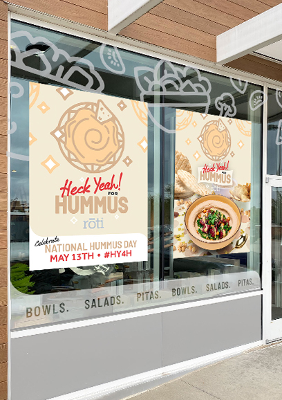 Two posters on the windows of Roti that say heck yeah for hummus.