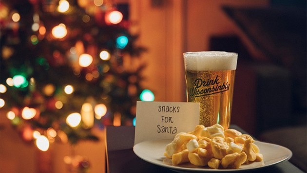 A plat of cheese curds and a beer next to a sign that says snacks for santa.