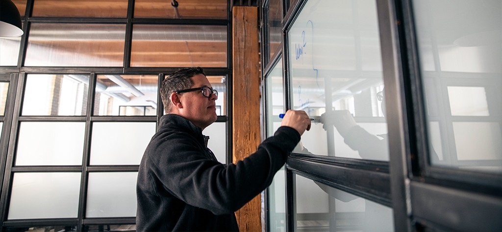 Cory writing on a dry erase board.