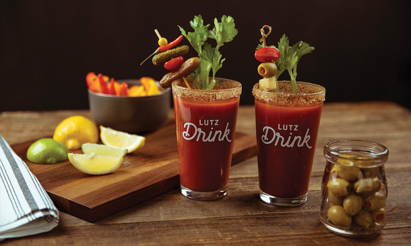 Two glasses that say Lutz Drink on it with a bloody mary in it.