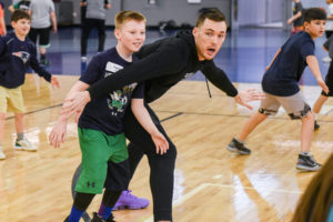 Pat Connaughton playing basketball against a young boy.