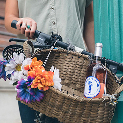 A bottle of french blue wine in a bike basket.